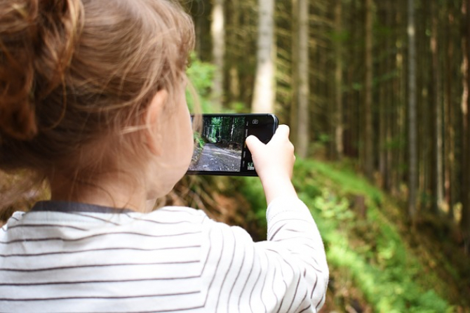 Copil ținând un smartphone în mână  FOTo: Pixabay