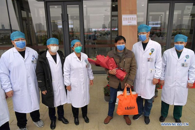 Un chinez vindecat de coronavirus. Pacientul, în mijlocul echipei medicale care l-a pus pe picioare. Foto: news.cn 