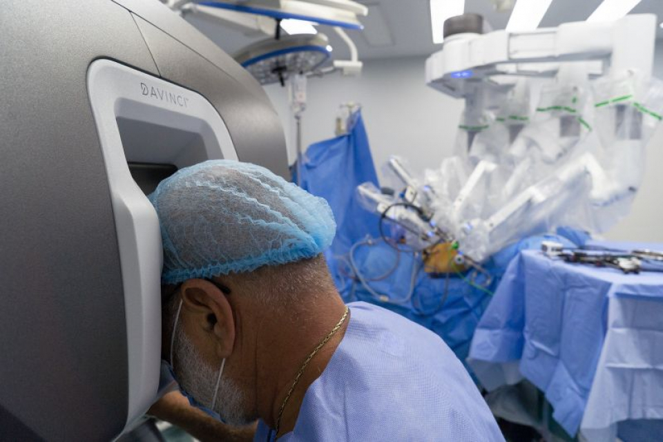 Chirurgul Bogdan Marțian în timp ce operează cu ajutorul sistemului robotic daVinci. Foto: Sanador